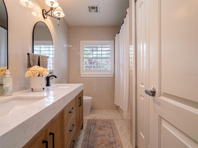 bathroom with vanity, walk in shower, a textured ceiling, and toilet