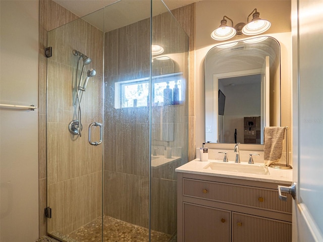 bathroom featuring vanity and a shower with door