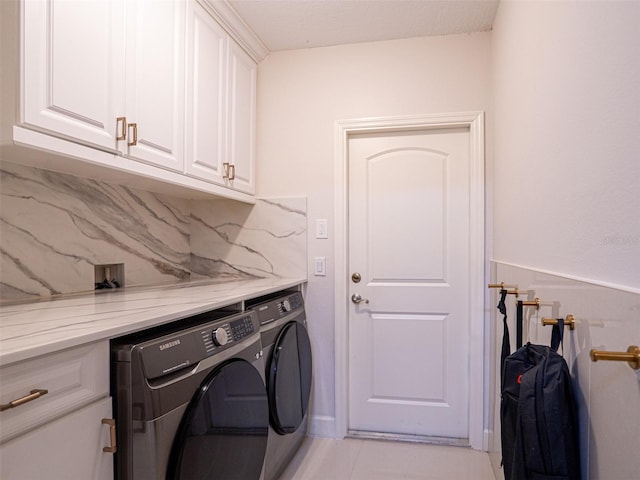 laundry room featuring separate washer and dryer, light tile patterned floors, and cabinets