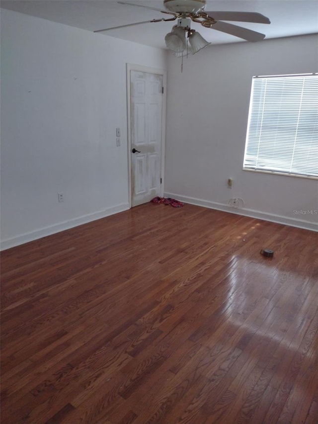 empty room with dark wood-type flooring and ceiling fan