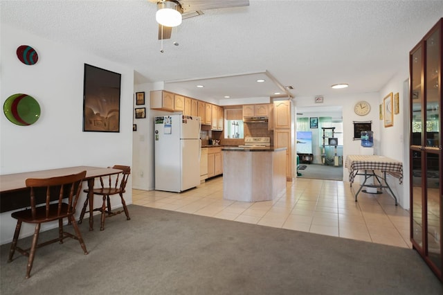 kitchen featuring light carpet, white appliances, a center island, and a textured ceiling