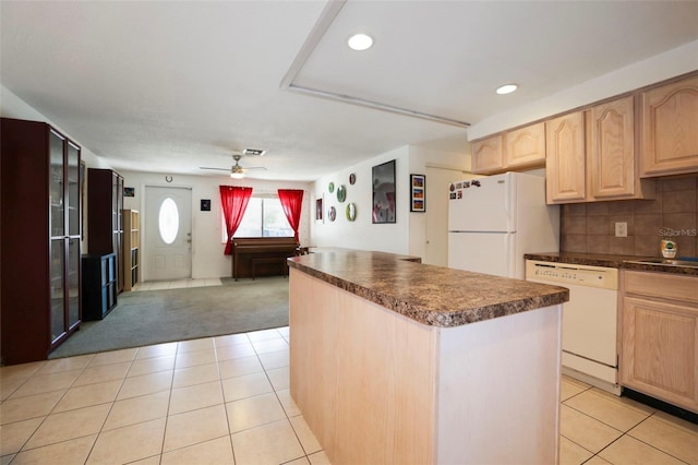 kitchen featuring decorative backsplash, white appliances, a kitchen island, and light brown cabinets