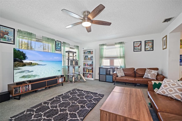 living room with ceiling fan, a textured ceiling, and carpet flooring