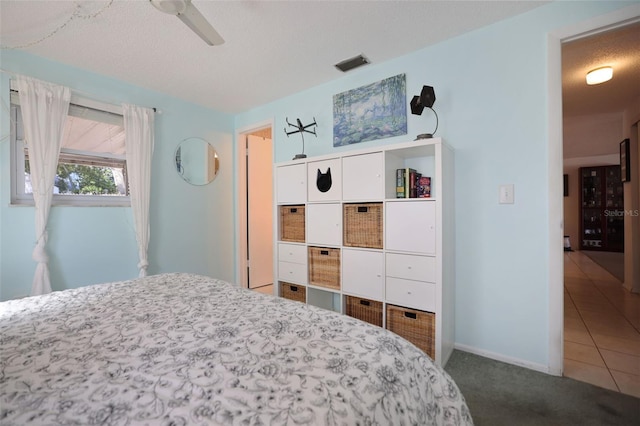 carpeted bedroom with ceiling fan and a textured ceiling