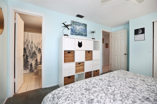 bedroom featuring ensuite bath and a textured ceiling