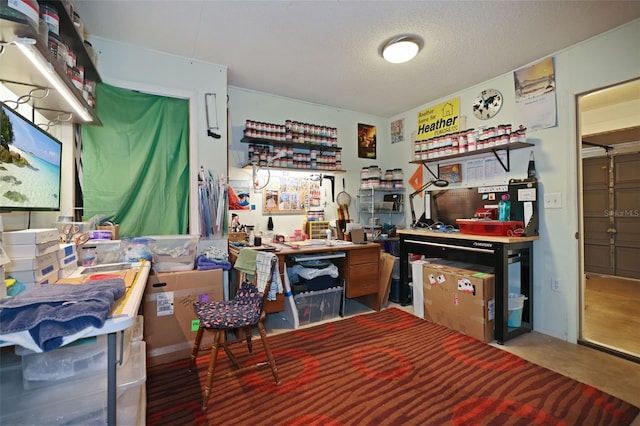 misc room with concrete flooring, a textured ceiling, and a workshop area