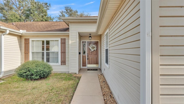 entrance to property with a lawn