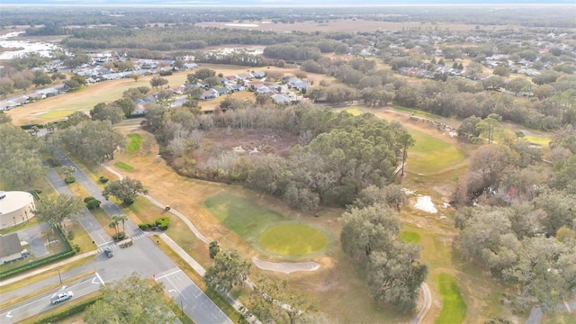 aerial view of property and surrounding area with a local golf course and nearby suburban area