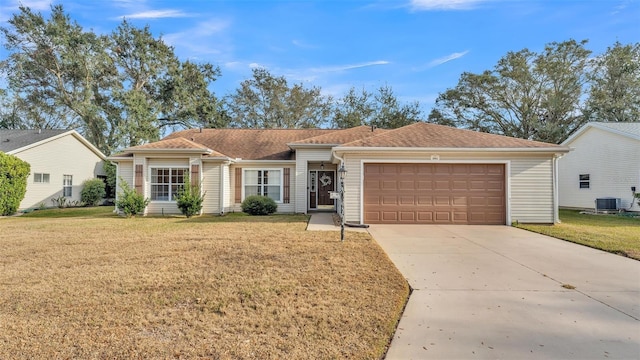 ranch-style home with a garage, a front lawn, and central air condition unit