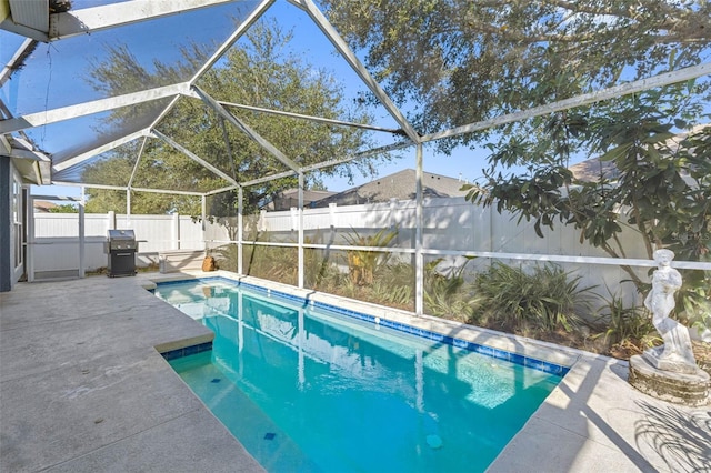 view of swimming pool featuring a grill, a lanai, and a patio area