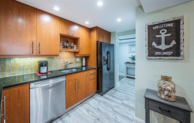 kitchen featuring black fridge with ice dispenser, sink, tasteful backsplash, dishwasher, and dark stone counters