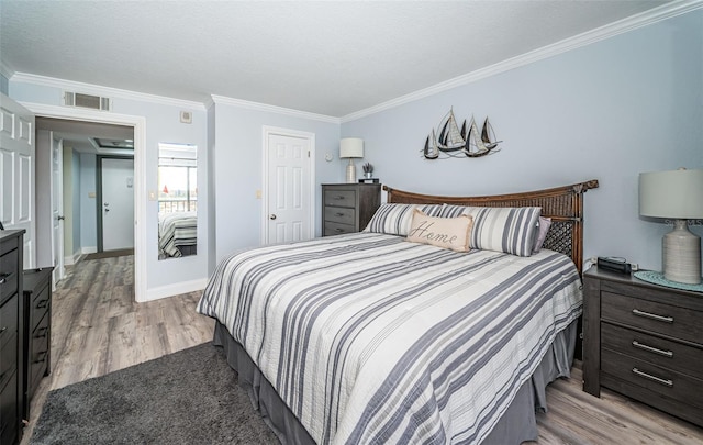 bedroom with ornamental molding, light hardwood / wood-style floors, and a textured ceiling