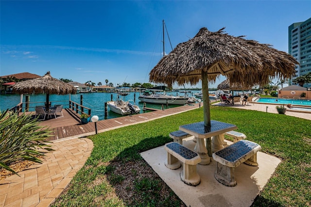 dock area featuring a water view, a yard, and a community pool