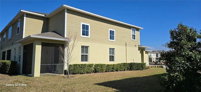 view of property exterior with a lawn and a sunroom