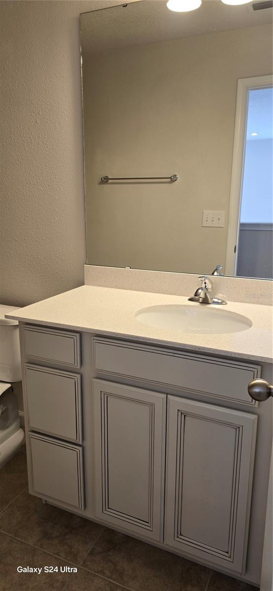 bathroom featuring vanity, tile patterned floors, and toilet