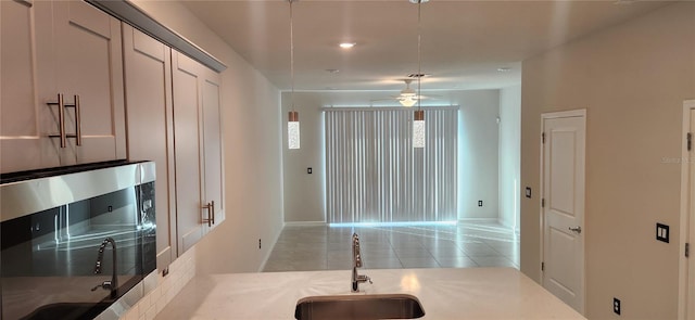 kitchen with sink, light tile patterned floors, and ceiling fan