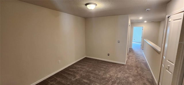 carpeted spare room with a textured ceiling