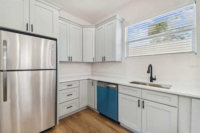 kitchen featuring light stone counters, sink, light hardwood / wood-style flooring, and stainless steel appliances