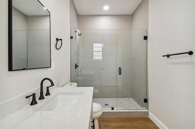 bathroom featuring hardwood / wood-style flooring, vanity, toilet, and an enclosed shower