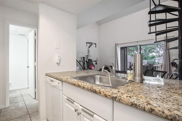 kitchen with sink, white cabinets, light tile patterned floors, light stone counters, and white dishwasher