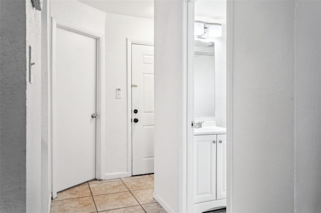 hallway with sink and light tile patterned floors