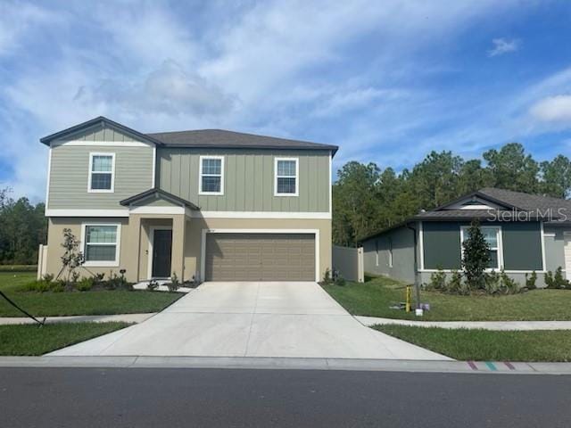 view of front of property with a garage and a front lawn