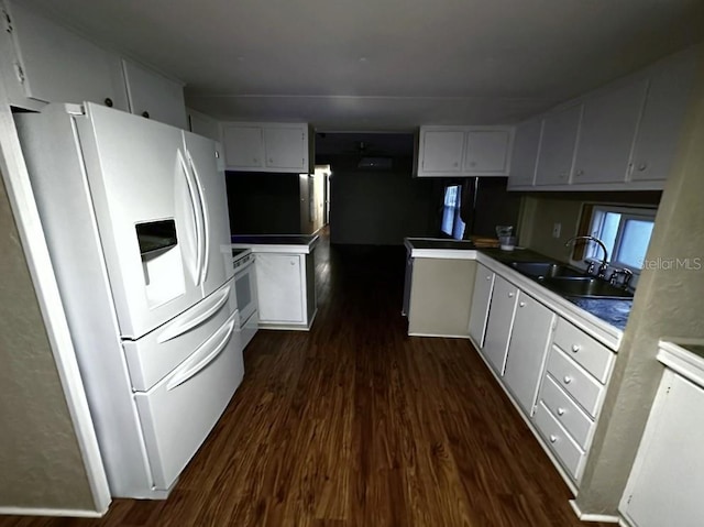 kitchen with dark hardwood / wood-style floors, white cabinetry, sink, kitchen peninsula, and white appliances