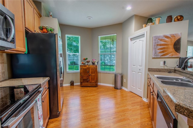 kitchen featuring stainless steel appliances, sink, and light wood-type flooring