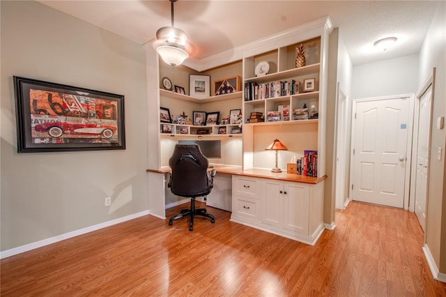 office space featuring built in desk and light hardwood / wood-style flooring