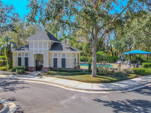 view of front of property with a fenced in pool