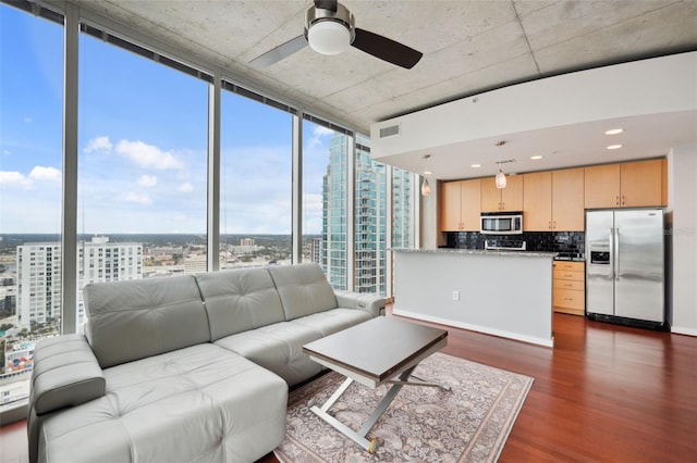 living room with dark wood-type flooring, expansive windows, and ceiling fan