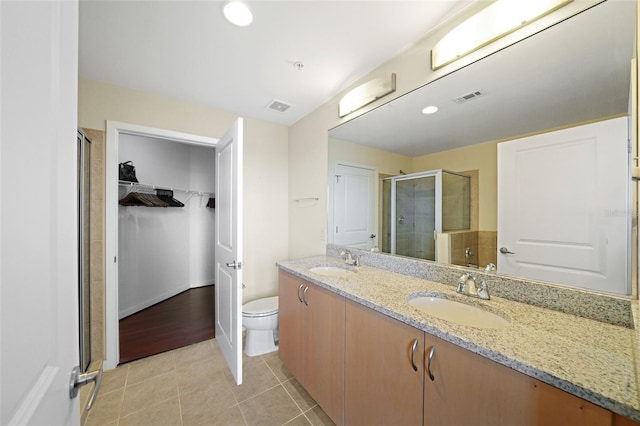 bathroom featuring walk in shower, tile patterned floors, toilet, and vanity