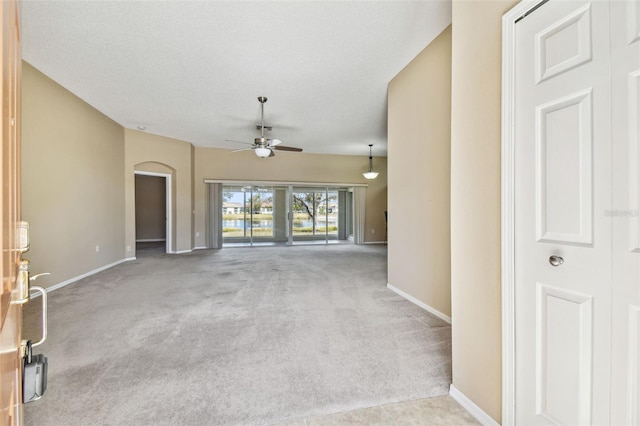 unfurnished living room featuring light colored carpet, a textured ceiling, and ceiling fan