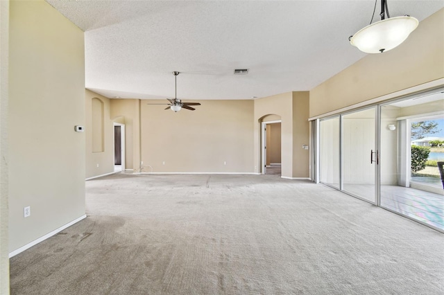 unfurnished living room featuring carpet flooring, a textured ceiling, and ceiling fan