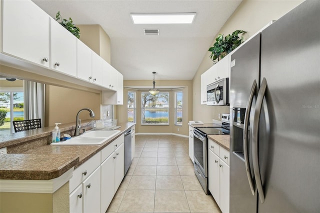 kitchen with pendant lighting, light tile patterned flooring, white cabinets, and appliances with stainless steel finishes