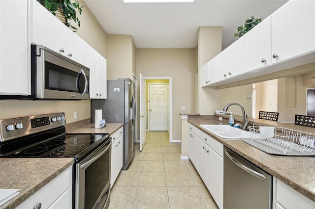 kitchen with white cabinetry, appliances with stainless steel finishes, sink, and light tile patterned floors