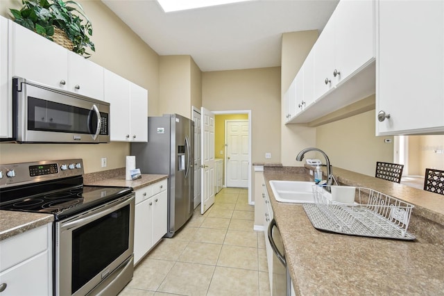 kitchen with white cabinetry, sink, stainless steel appliances, and light tile patterned flooring