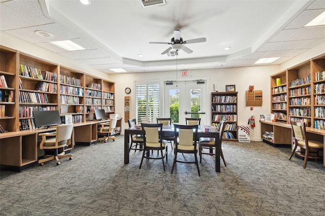 dining area with ceiling fan and dark carpet