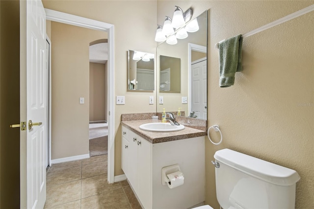 bathroom featuring vanity, tile patterned floors, and toilet