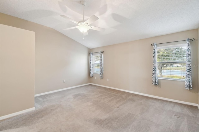 spare room featuring plenty of natural light, light colored carpet, and vaulted ceiling