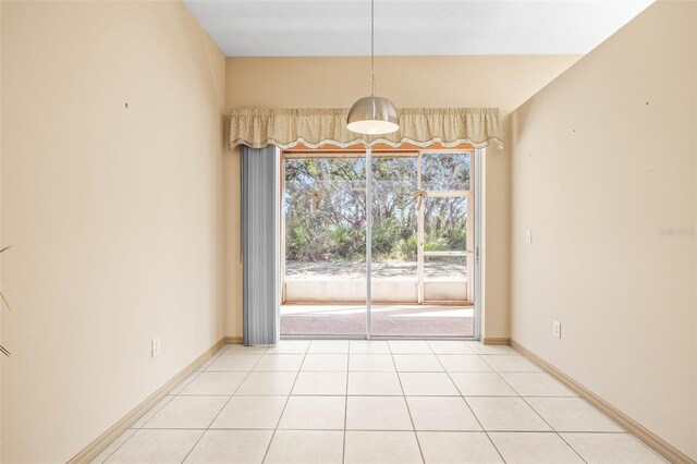 empty room featuring light tile patterned floors and baseboards