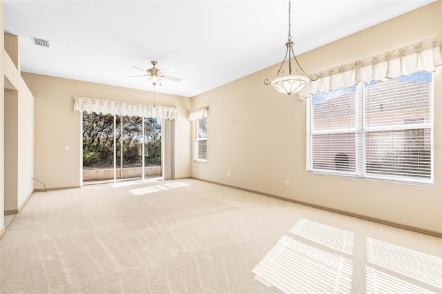 unfurnished room with ceiling fan, carpet, visible vents, and baseboards