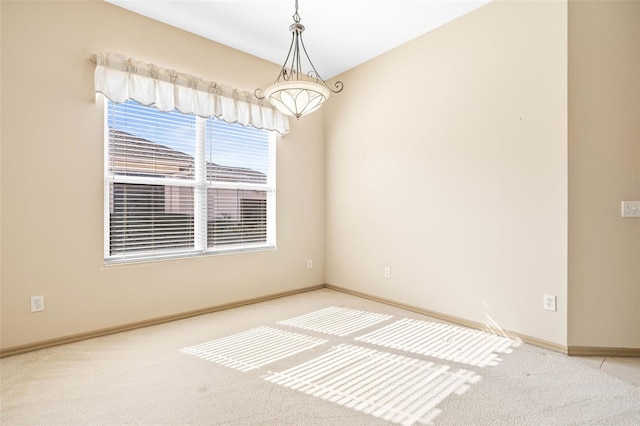 carpeted spare room featuring baseboards