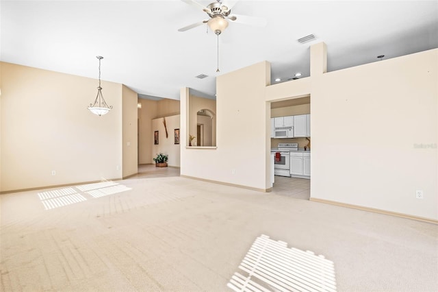 unfurnished living room with ceiling fan, visible vents, baseboards, and light colored carpet