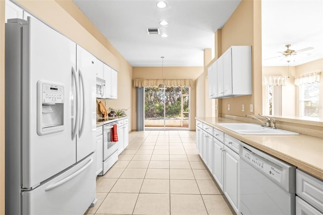 kitchen with white appliances, light tile patterned floors, white cabinetry, and light countertops