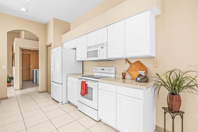 kitchen featuring white appliances, light tile patterned floors, white cabinetry, and light countertops