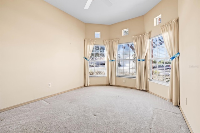 empty room featuring carpet floors, a ceiling fan, and baseboards