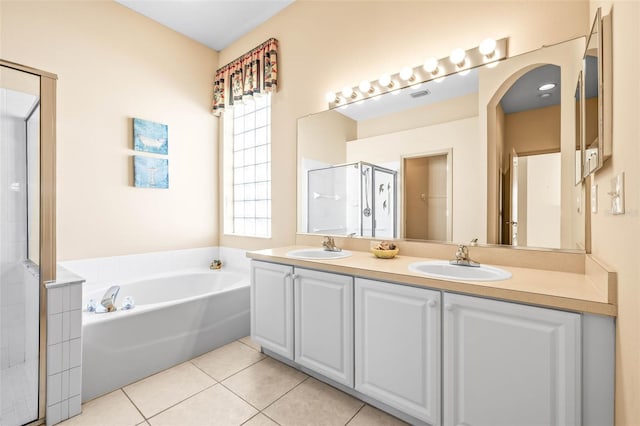 full bath featuring a garden tub, a sink, tile patterned floors, double vanity, and a stall shower