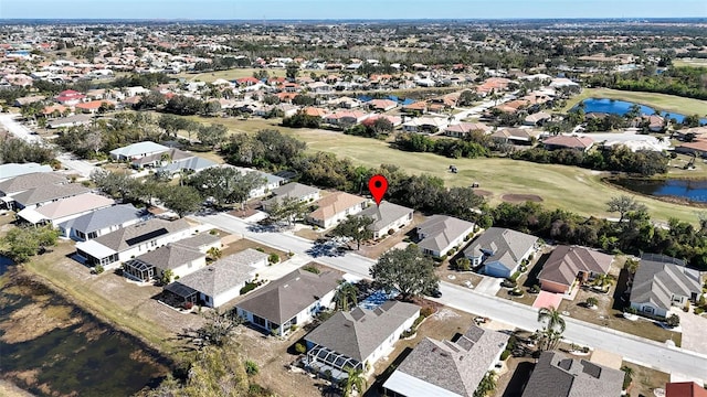 drone / aerial view featuring view of golf course, a water view, and a residential view