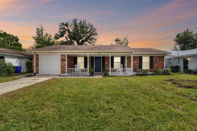 single story home with a garage, a yard, and covered porch